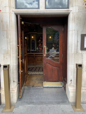 Wooden doors push to open in centre where doors meet via high metal handles.