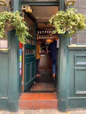 Green door with glass panels ahead. Push door to open via right side with no handle.