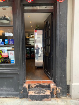 Black wooden door, push to open on left side.