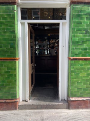 Brown framed glass door push to open on right side via small round handle.