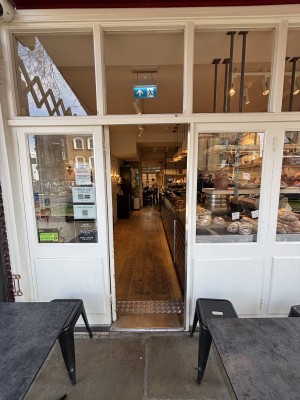 Glass door with white frame ahead. Push from right to open.