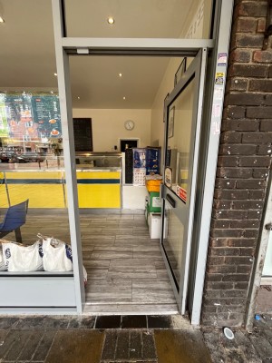 Push glass door with handle on the left.