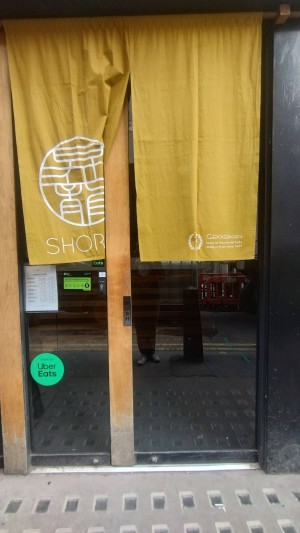 Glass door with curtains until middle. Push open on the wooden strip.