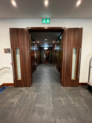 Double doors at back of hotel lobby. Pull from middle to open. Second set of doors ahead past lifts.