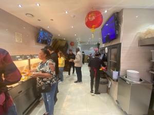 Looking straight from entrance. Self service food counter on the left. Seating area to the back. Path in the middle.