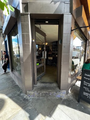 Main doorway on left corner of venue. Push door from right. One step up to door, another step through door.
