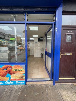 Blue bordered glass door ahead. Push to enter on the left side.