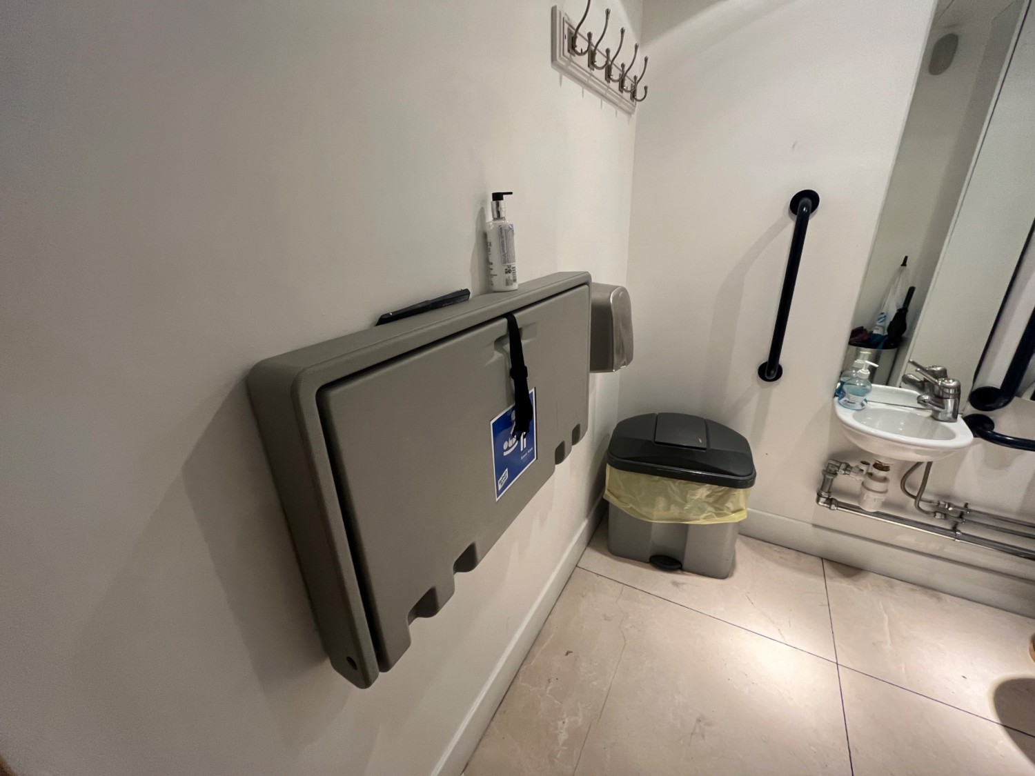 Left side of bathroom from doorway. Baby changing station on left wall.