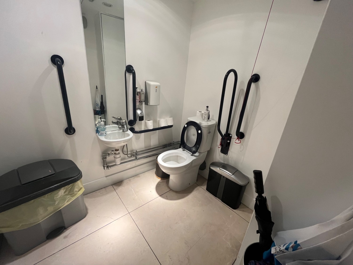 Right side of bathroom from doorway. Toilet on right wall. Sink ahead. Pull cord on left when seated.
