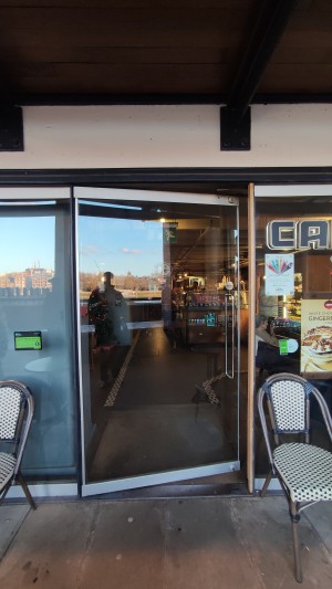 Glass door ahead. Push metal handle on right to open.