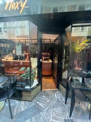 Glass push door in black frame. Push on left of door to open.