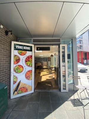 Door with poster ahead. Pull white handle on right to open.