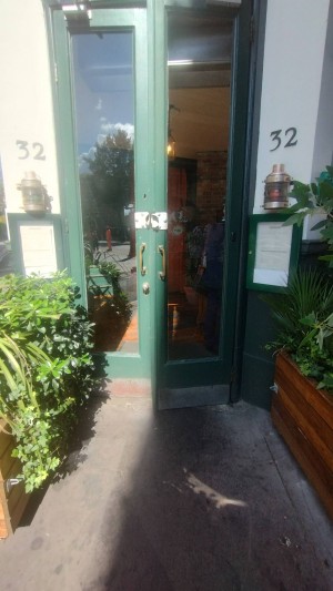 Double glass door with green frame. Pull open from middle.
