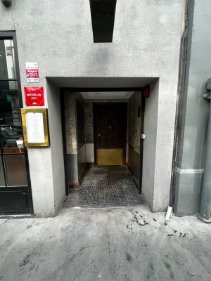 Main entrance from street. First door ahead through alley.
