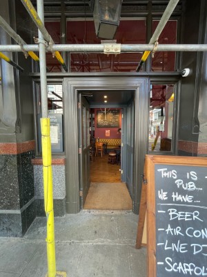 First door. Brown doorframe. Push door open from the right.