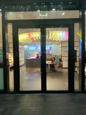 Glass doors with black frame. Pull handle to right of left-hand door to open.
