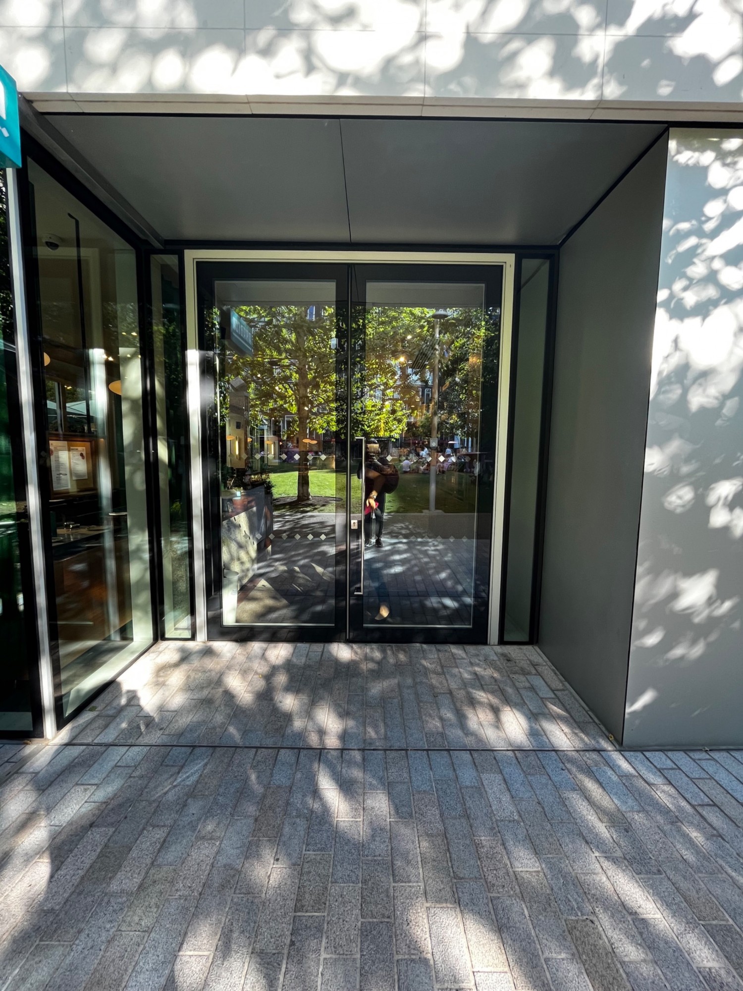 Glass double doors with black frame. Pull from right side to open.