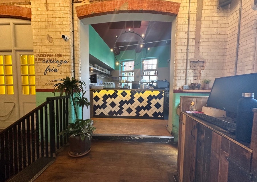 From after welcome desk, looking right. Stairs on left. Service bar counter at back right.