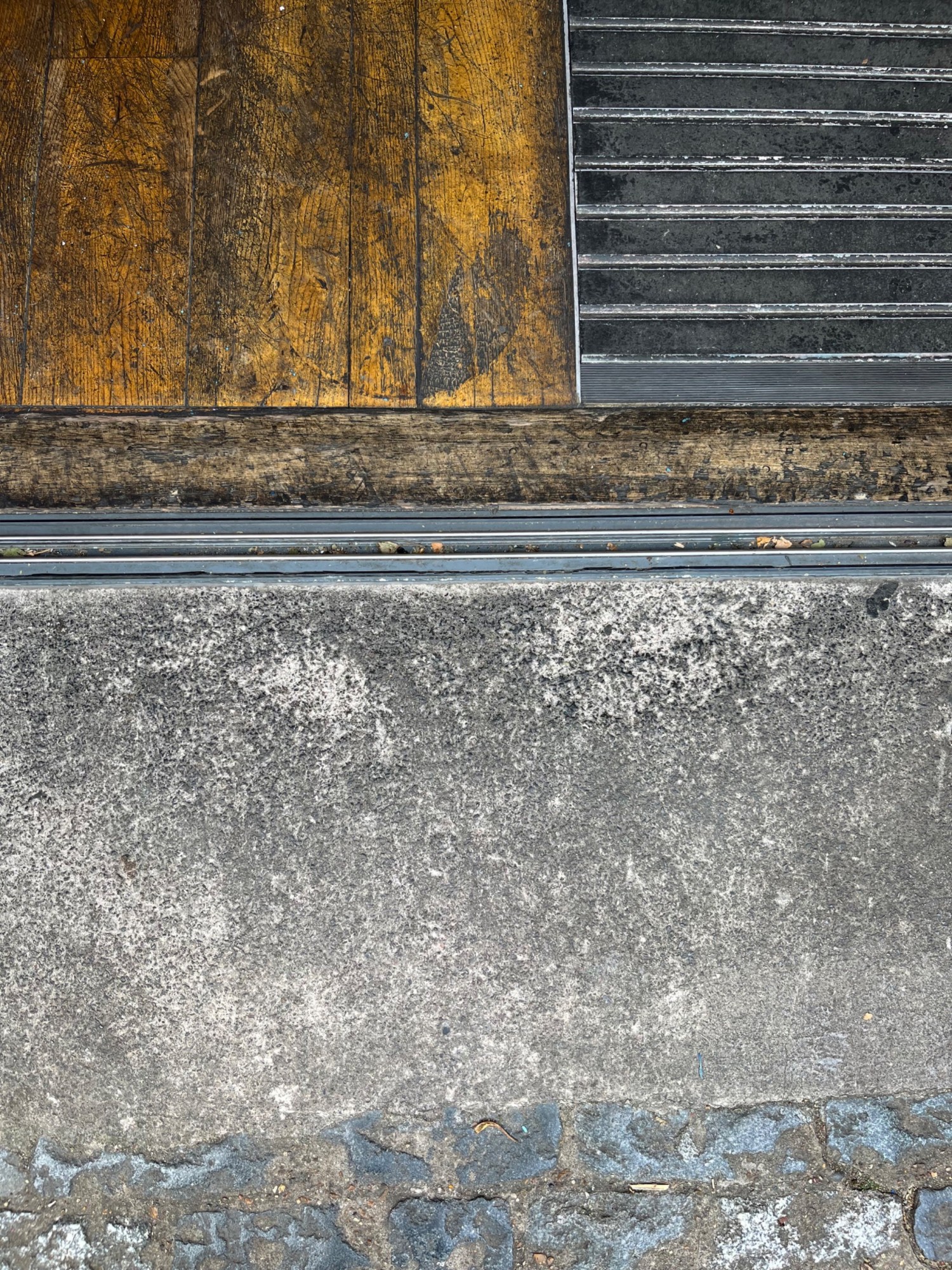 Raised edge at threshold, followed by doormat.