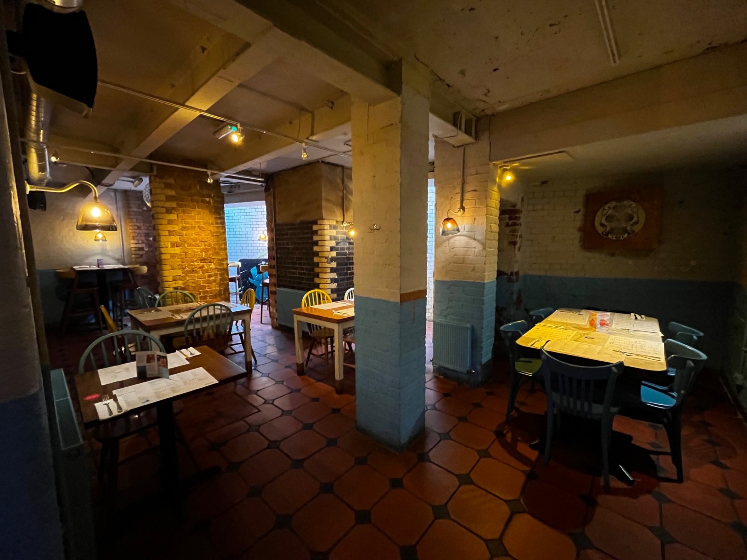 Continuation of main are to right. Tables and chairs throughout space. Area continues further right.