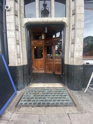 First set of double doors. Black wooden doors. No handles. Push from centre to open.