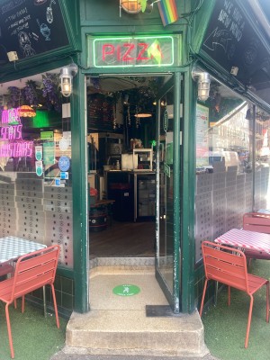 Access via glass door with green frame. Open via vertical metal handrail on left.