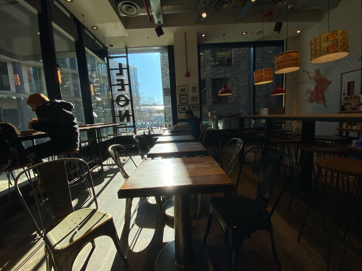 From start of tables and chairs facing straight. Tables and chairs ahead. High tables and stools on both sides.