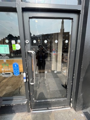 Black framed glass door. Push silver handle on left to open.