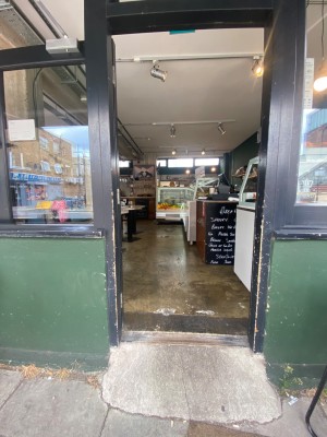 Single door with black wooden frame. Push door open from the right.