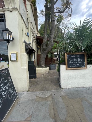 Sliding gate separating venue from street area. Main entrance to the left, following the gate.