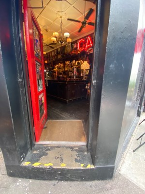 Red door with glass panels. Push door to open via handle on right.