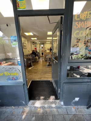 Push glass door with handle on left.