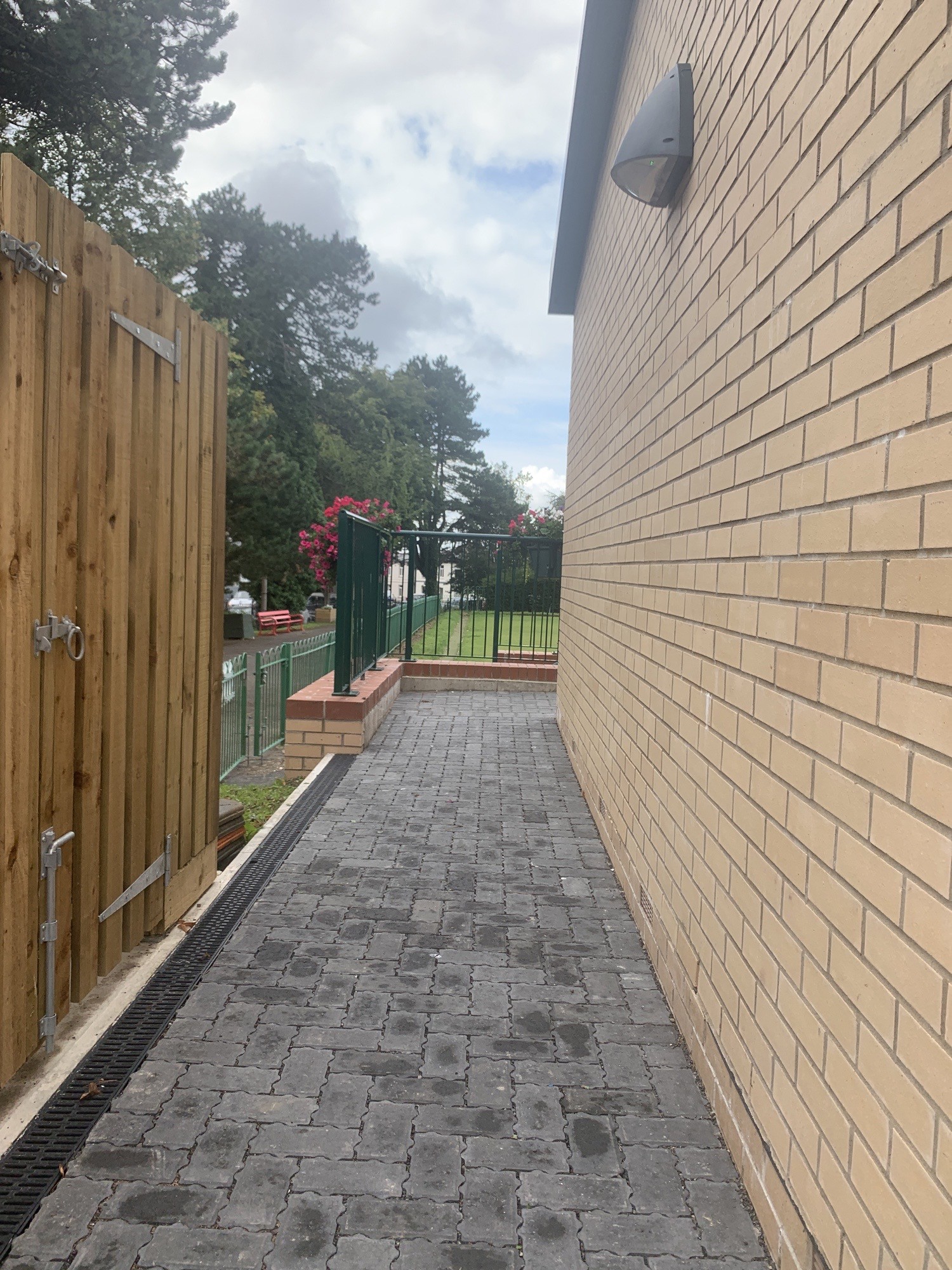 Soft-inclining brick ramp leading up to side area. Turns right at the top of ramp.