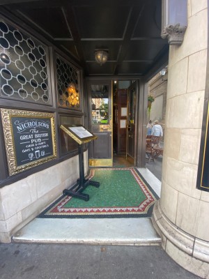 Facing entrance. 1 step before doorway.