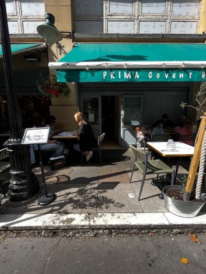 Path to entrance door. One step up from street. Path obstructed by outdoor seating on left and right.