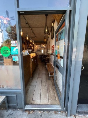 Glass door with grey frame. Push handle from left to open.