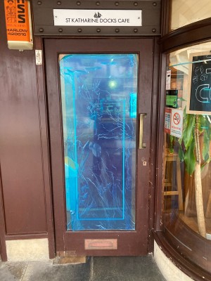 Glass door with wooden frame ahead. Pull door to open via handle on right.