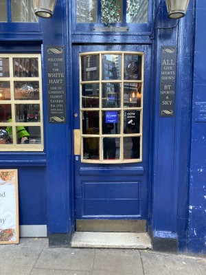 Blue door with glass panels ahead. Push door to open from left.