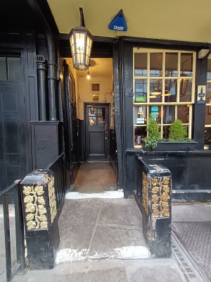 From street, facing venue. Steps ahead to doorway. Black, metal barriers along both sides.