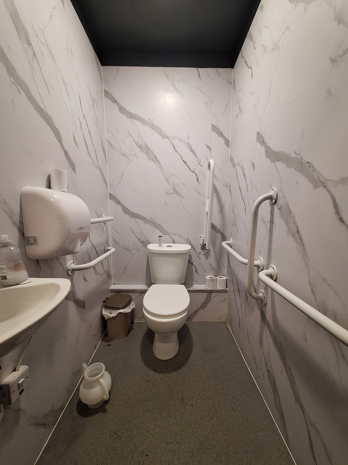 From door facing straight. Sink on left. Toilet on back centre.