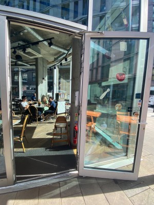 Pull glass door with handle on the left.