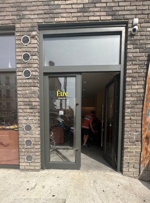 Dark grey framed glass doors. Push grey handle on left of right door to open.