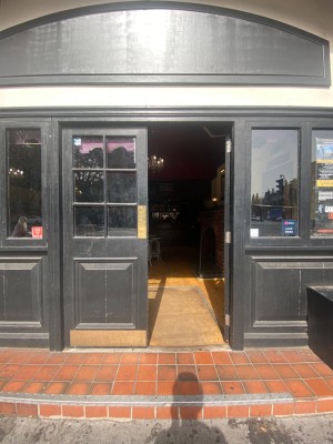 Glass and painted black wooden double doors. Push from middle to open.
