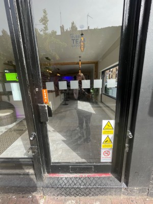 Single door with black door frame. Push door open from the left.