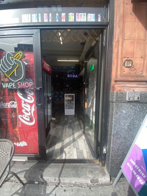 Glass door with black frame. Push from left to open. Go straight for main area.