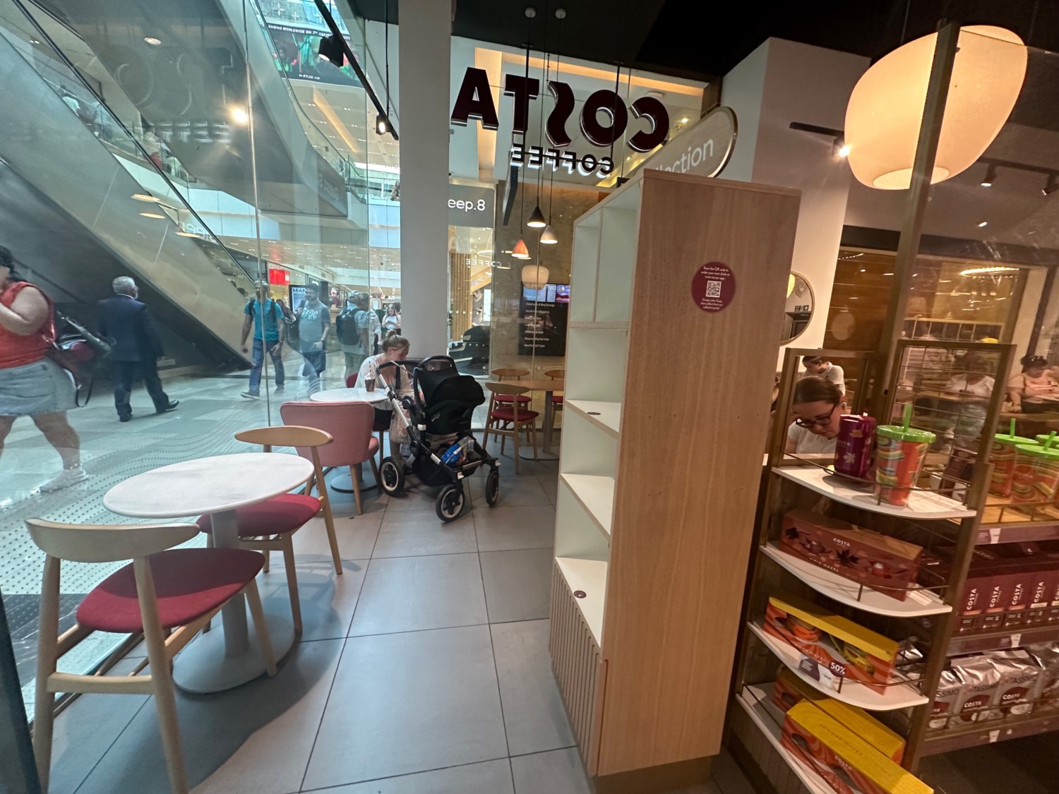 From entrance facing left. Tables and chairs along left. Product shelves to right.