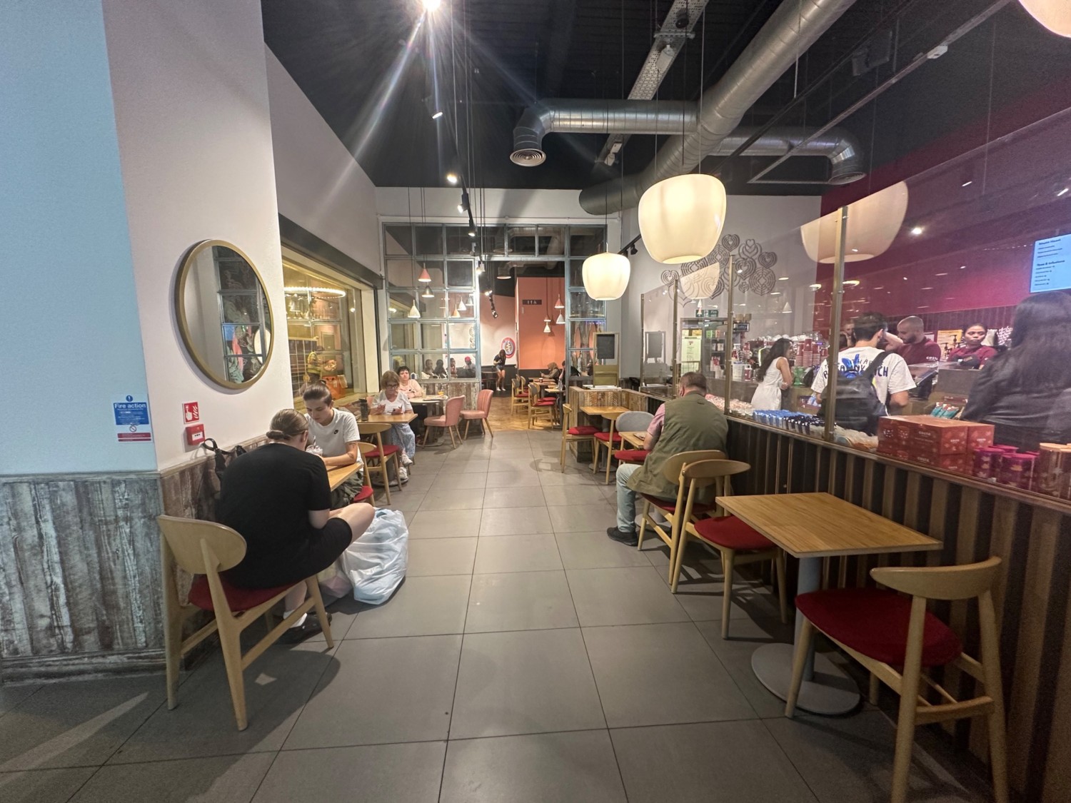 From after product shelves facing right. Tables and chairs along left and right.
