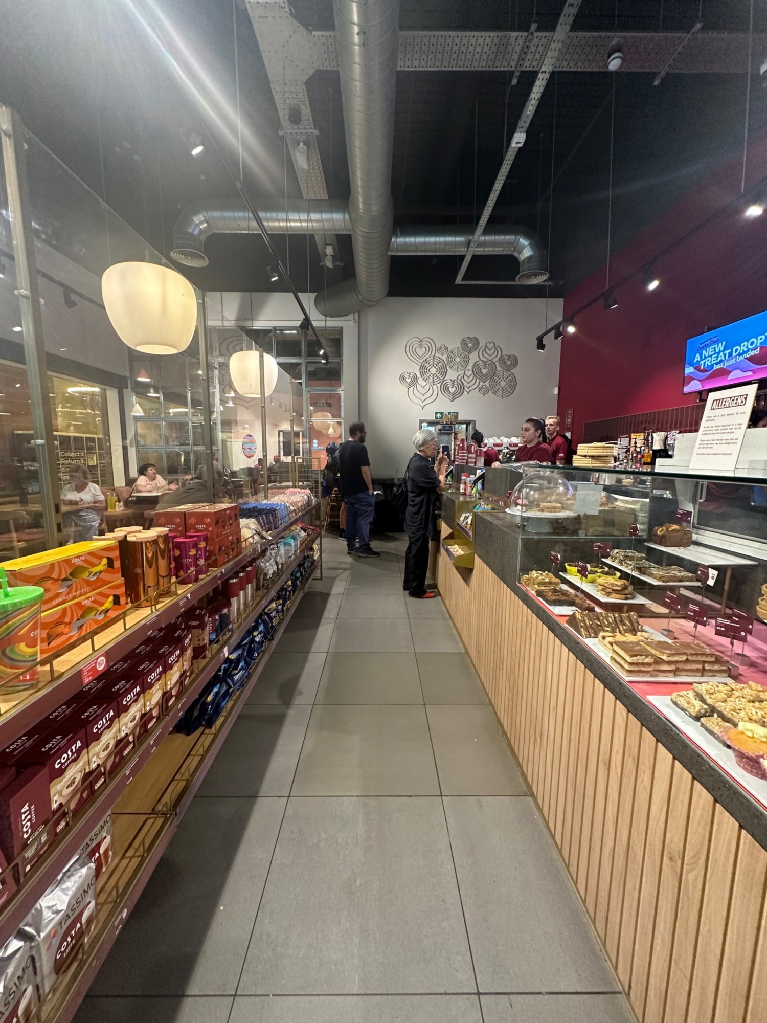From corner of counter facing straight. Counter along right. Product shelves along left.
