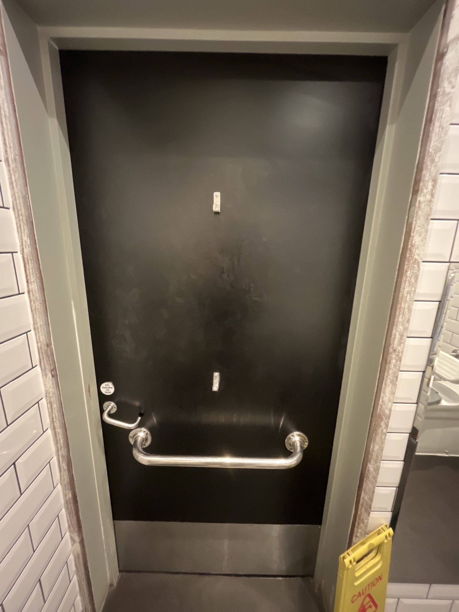 Back of bathroom door. Grab rail across centre. Seated height and high hanging hook above. Push handle on left to open.