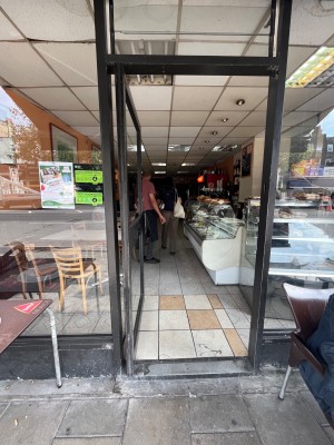 Glass push door with black handle on the right.